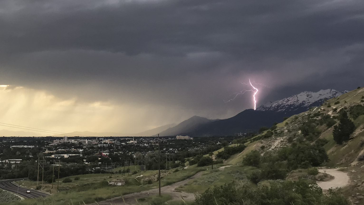 purple lightning strikes timpanogus mountain in the distance